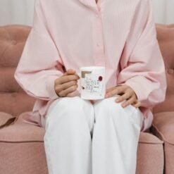Femme assise sur un canapé tenant le mug lettre d’amour