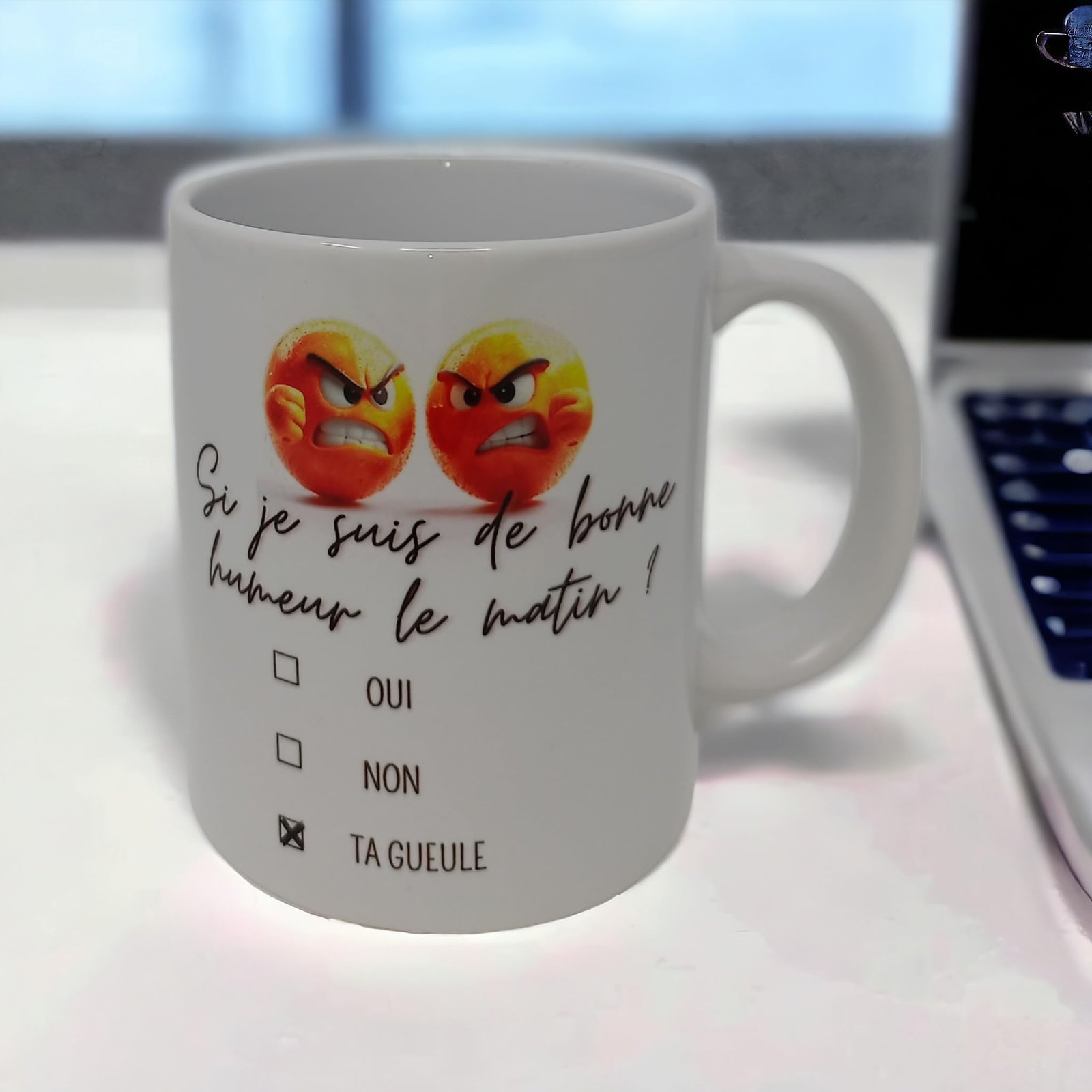 Mug humeur du matin à côté d’un ordinateur portable