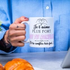 Homme tenant le mug Je t’aime plus fort que tu ronfles au petit-déjeuner