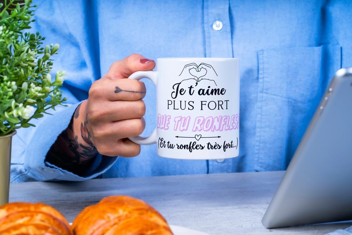 Homme tenant le mug Je t’aime plus fort que tu ronfles au petit-déjeuner
