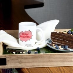 Mug Super Maîtresse sur un plateau avec un gâteau au chocolat