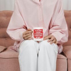 Femme assise sur un canapé rose avec le mug frôler la perfection