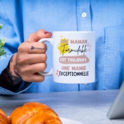 Femme tenant le mug annonce grossesse future mamie à côté de croissants