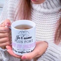 Femme en pull tenant le mug Je t’aime plus fort que tu ronfles