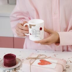 Femme tenant le mug lettre d’amour près d’un cadeau