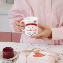 Femme tenant le mug Saint-Valentin à côté d’un cadeau