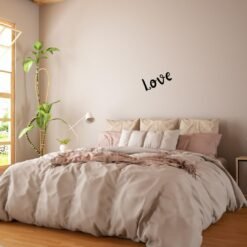 Sticker mural personnalisé Love posé au-dessus d’un lit