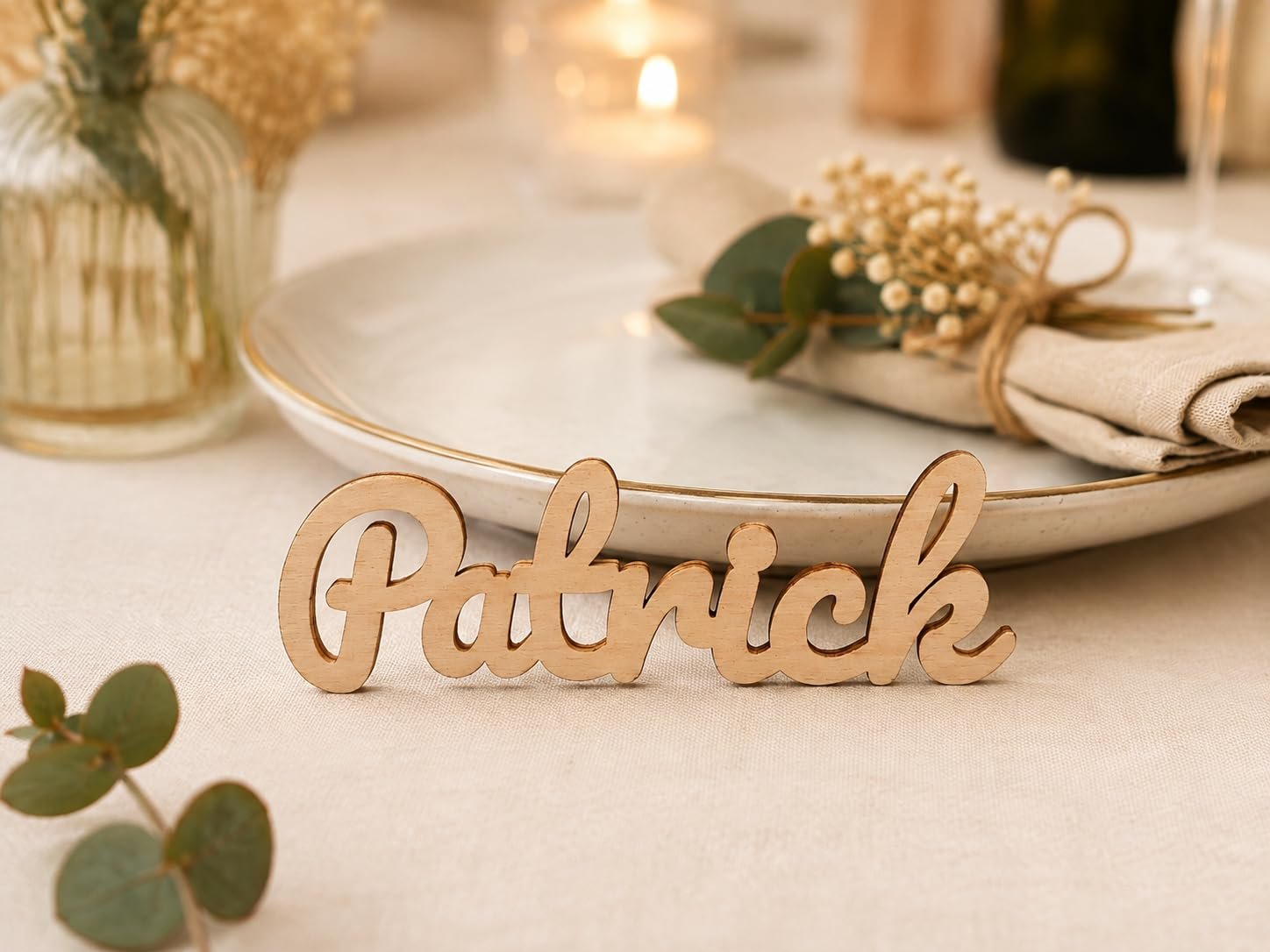 Marque-place en bois au prénom Patrick posé devant une assiette et une serviette décorée de gypsophile
